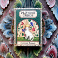 Playing card box with a strange medieval cat illustration on a decorative background