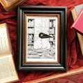 "The Library" print in a dark wooden frame: Birdface sits among bookshelves, framed on red cloth with old books