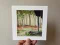 "The Big Friend" print held in a hand: Tiny Noot beside the huge clawed foot of a giant creacher in a forest