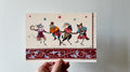 "The Mummers" print held in a hand: four costumed animal figures dancing above a red patterned border