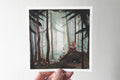 "The Trollmother" print held in a hand: a troll mother sits on a mossy mound in a misty forest